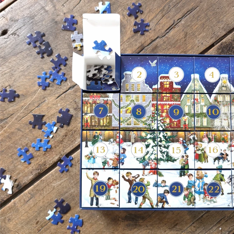 Weihnachtliche Schachtel mit kleinen, nummerierten Boxen, die Puzzleteile enthalten