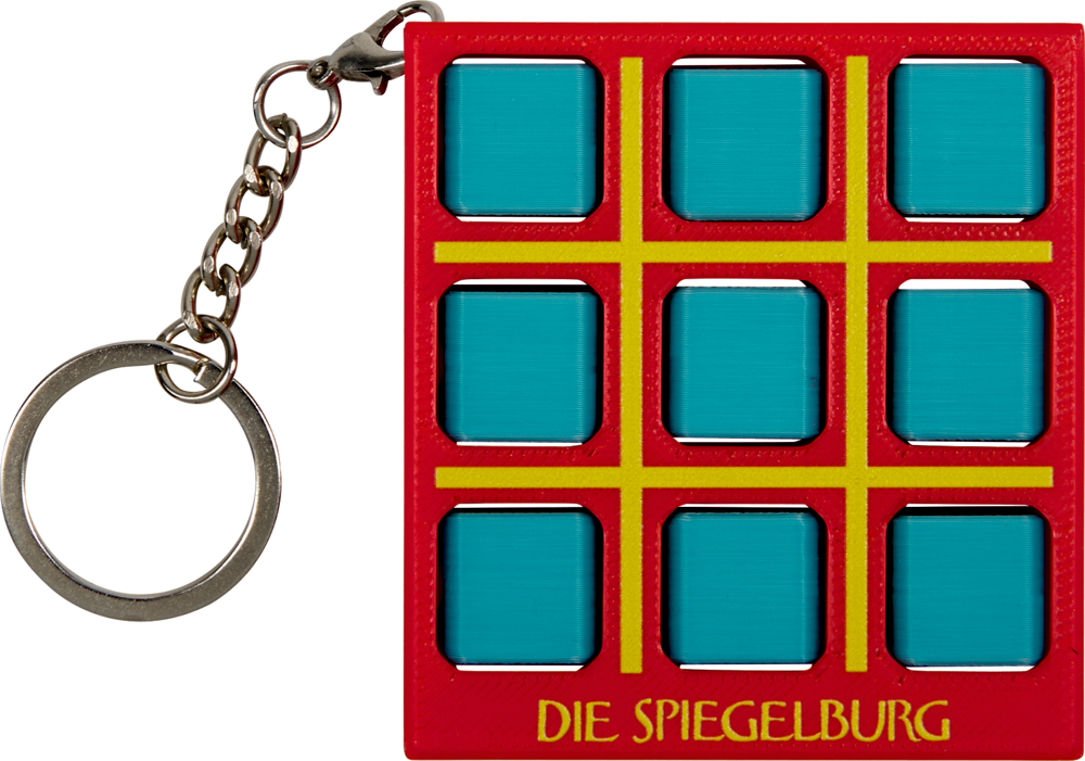 Roter Schlüsselanhänger mit verdeckten Tic-Tac-Toe-Steinen.
